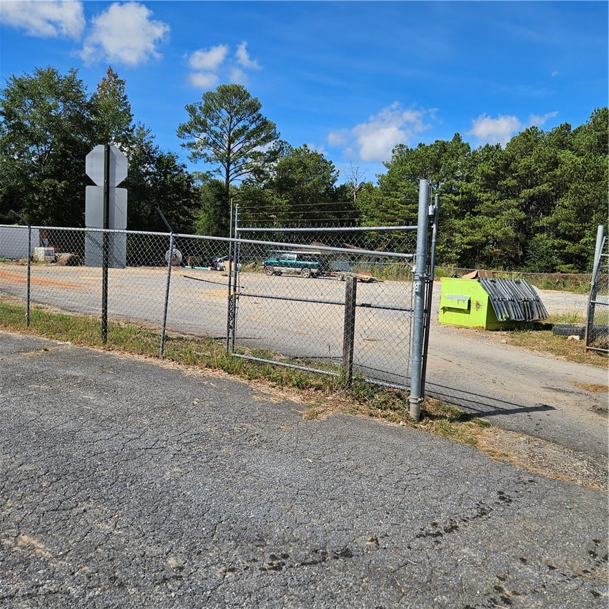 22234 US-280, Dadeville, AL 36853, Secure chain-link fencing borders a paved access d