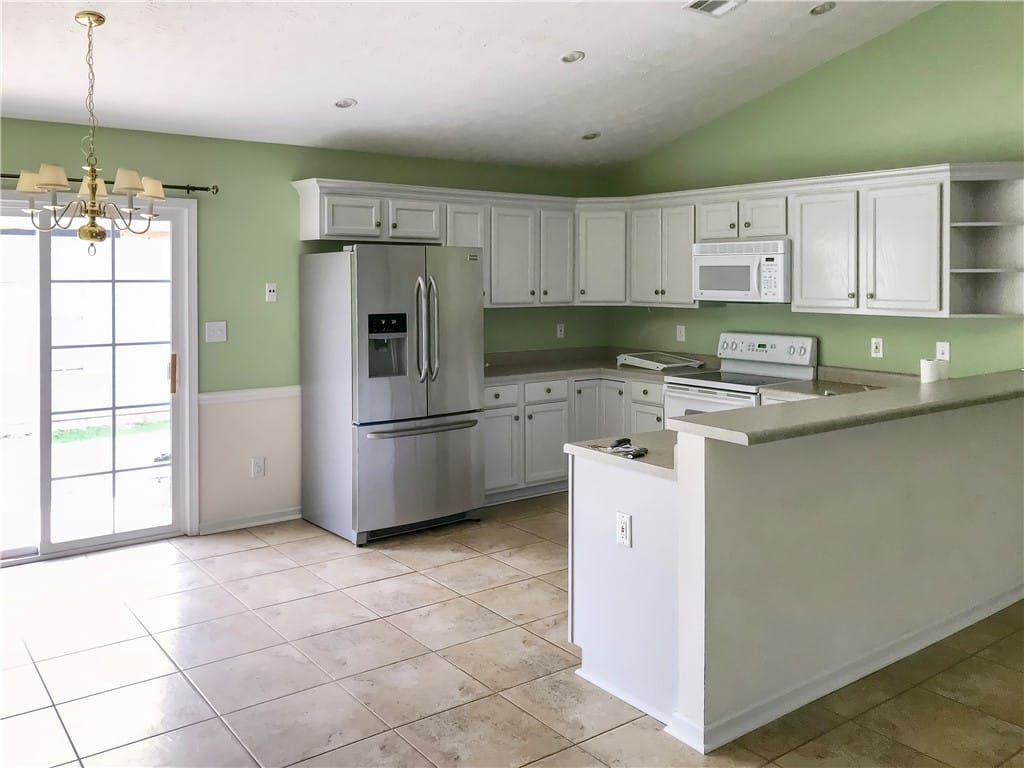 738 Whitaker Ln, Auburn, AL 36830, A cheerful kitchen space features a practical brea