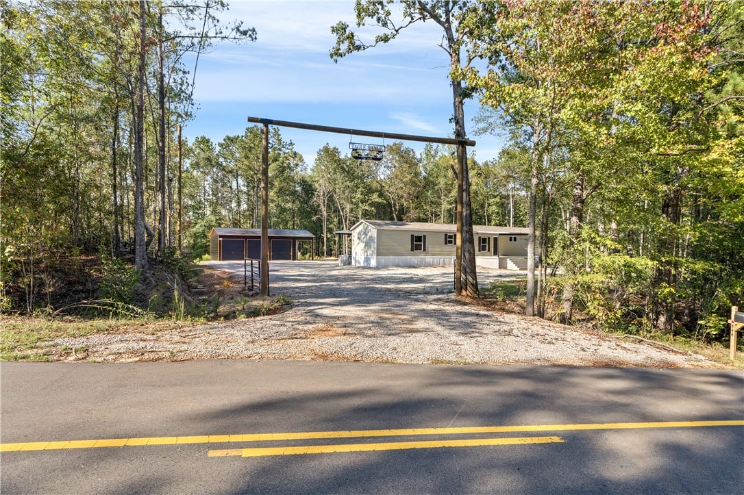 444 Co Rd 17, Tuskegee, AL 36083, A private gravel driveway framed by mature trees l