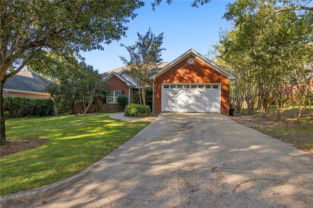 546 Rosemary Ct, Auburn, AL 36830, Mature trees frame a classic brick exterior comple
